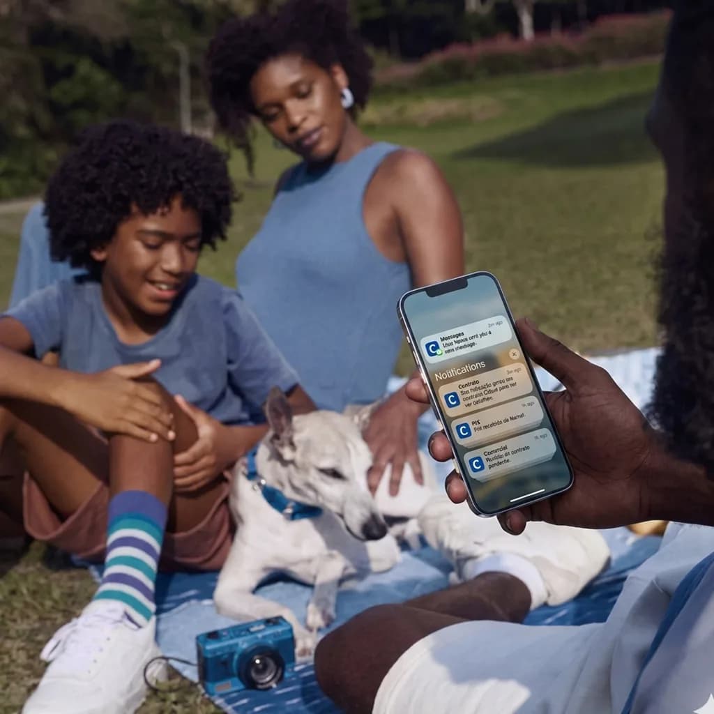 Família recebendo notificação de indicação no celular ao ar livre